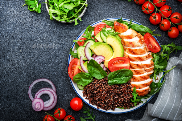 Healthy Lunch with grilled chicken, red quinoa salad with tomatoes, avocado, arugula and  - Stock Photo - Images