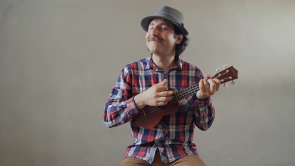 Funny Young Man Playing a Ukulele or Toy Guitar - Isolated on White Background alt