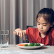 Asian little girl eating healthy vegetables with relish. - PhotoDune Item for Sale