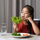 Asian little girl eating healthy vegetables with relish. - PhotoDune Item for Sale