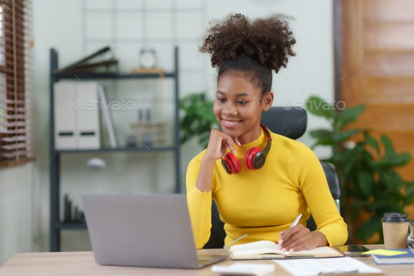 Young woman curly hair working on laptop and take note at home. - Stock Photo - Images