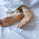  young Woman lying with bare feet in bed, - PhotoDune Item for Sale