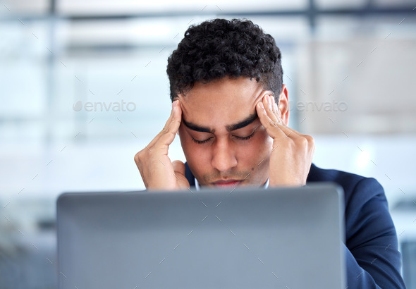 One exhausted mixed race businessman rubbing forehead with headache and computer vision eye strain