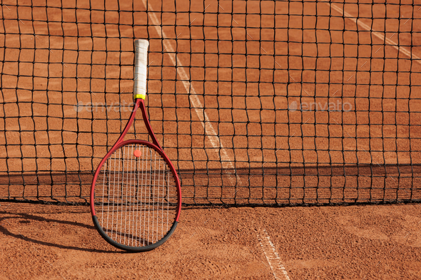 tennis racket is at net tennis court made of red clay soil with markings for game or competition - Stock Photo - Images