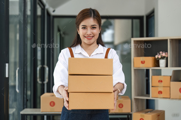 Happy asian woman work from home packaging, on line marketing packaging and delivery, SME concept - Stock Photo - Images