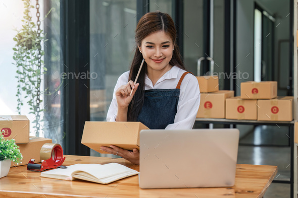 Woman who e-commerce business is writing a list of customers on paper before shipping to them, she - Stock Photo - Images
