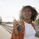 Black woman wearing headphones and walking on the bridge - PhotoDune Item for Sale