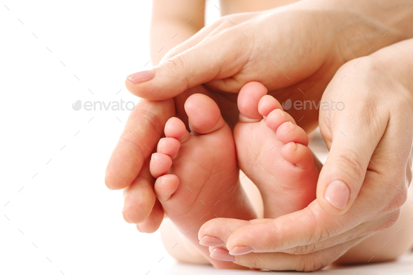 Mother massaging little child\'s feet and soles.