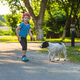 A child plays with a small dog in the park. Selective focus. - PhotoDune Item for Sale