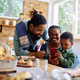 Happy black family using smart phone at dining table. - PhotoDune Item for Sale