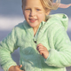 A 5-year-old girl in a green jacket is running - PhotoDune Item for Sale