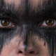 Closeup portrait of young female with horror black stage makeup painted on face, looking at camera - PhotoDune Item for Sale