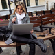young blond woman journalist with a laptop sits on the terrace in a cafe - PhotoDune Item for Sale