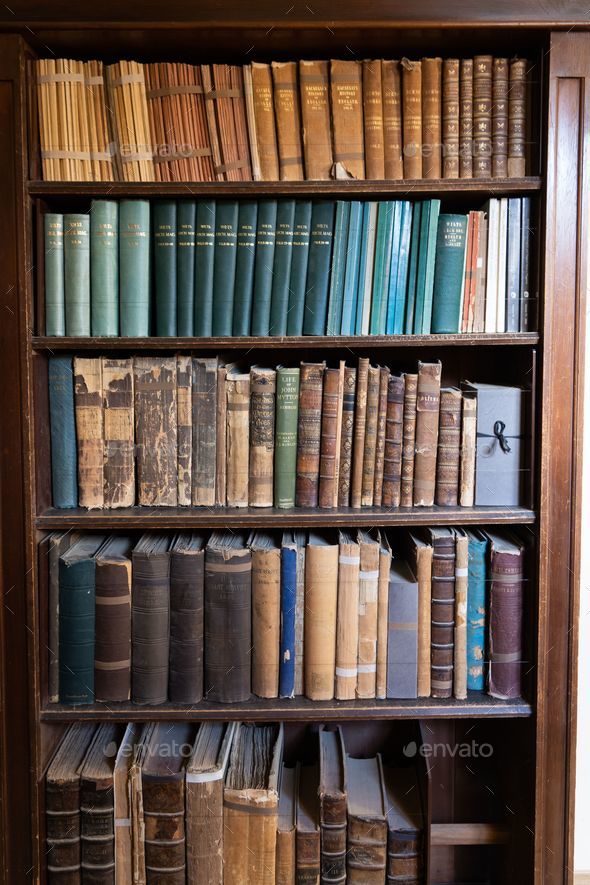 Vertical closeup of the antique books on the bookshelf. Stock