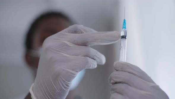 Closeup Covid Vax in Syringe in Male African American Hands alt