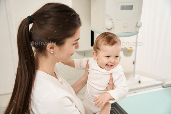 Mother getting baby ready for digital radiography