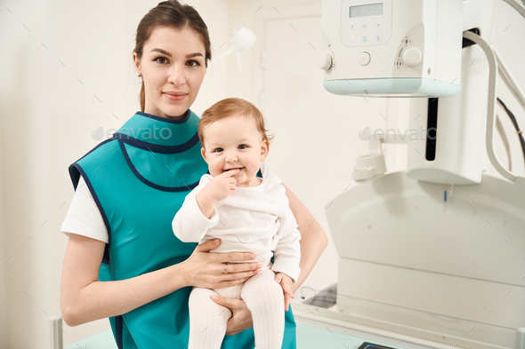 Female and pleased little baby in radiography room