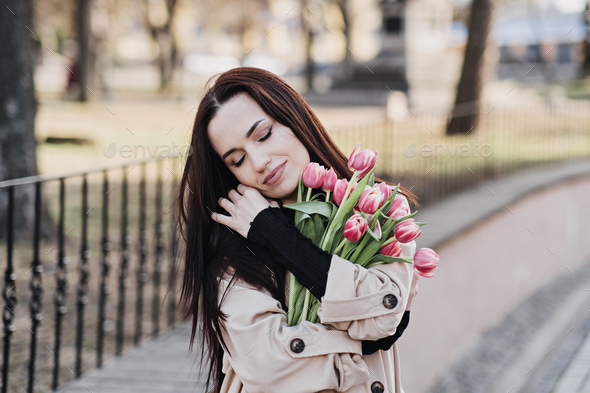 Self Care, Buy yourself flowers. Beautiful woman giving herself flowers and enjoying life outdoors - Stock Photo - Images