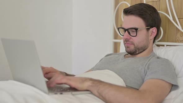 Beard Young Man Saying Yes with Head Sign in Bed alt