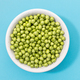 Fresh green peas in bowl isolated on blue background. - PhotoDune Item for Sale