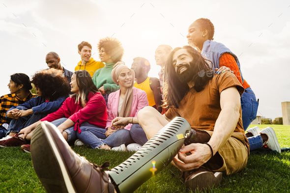 Multi ethnic group having fun in a public park - Amputee man hangs out with his friends outdoor