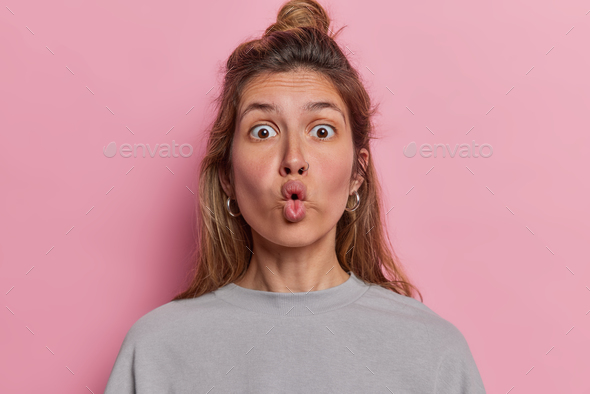 Portrait of surprised young woman makes fish lips has stunned amazed ...