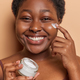Dark skinned female applies daily skincare moisturizing nourishing facial cream undergoes anti - PhotoDune Item for Sale