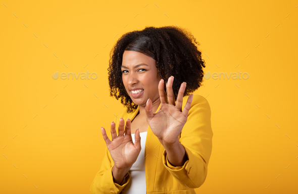 Displeased young african american lady making stop gesture with hands, push back camera, isolated on