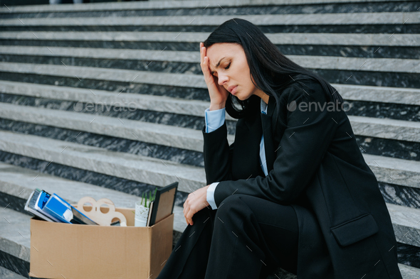 Unemployed Woman Sitting on Stairs with Head Down