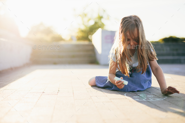 Kid drawing on pavement in urban neighborhood at summer - Stock Photo - Images