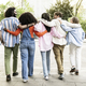 Back view of diverse people hugging each other while walking in the street. Rear view of a group of - PhotoDune Item for Sale