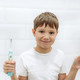 cute 8 years old boy holding bamboo and electric tooth brush making choice - PhotoDune Item for Sale