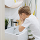 cute 6 years old boy washing his face over the sink in bathroom. Image with selective focus - PhotoDune Item for Sale