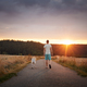 Man walking with dog together on rural road at sunset - PhotoDune Item for Sale
