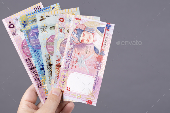 Omani money in the hand on a gray background - Stock Photo - Images