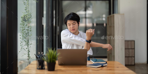 Stretching oneself asian business man with laptop in cafe. tried from work,  stretch oneself Stock Photo by nateemee
