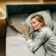 Lifestyle portrait of a woman in pajamas sleeping while lying in bed  blissfully. - PhotoDune Item for Sale