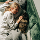 A woman in the morning after waking up lies in bed and pets a domestic cat. - PhotoDune Item for Sale