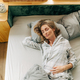 Carefree woman sleeping in bed early in the morning. - PhotoDune Item for Sale