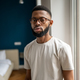 Portrait serious african american bearded man in eyeglasses in white t-shirt near window at home - PhotoDune Item for Sale