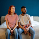 Pensive multiracial family couple sitting on comfortable bed daydreaming together looking to window. - PhotoDune Item for Sale
