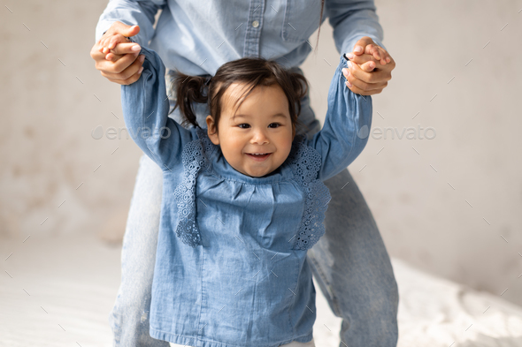 Asian Toddler Baby Learning To Walk Holding Mommy\'s Hands Indoor