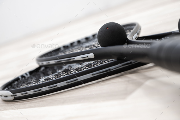 Squash Rockets and a Ball on a Court Floor Close Up Photo. - Stock Photo - Images