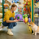 Young woman buying new toy for her corgi dog at pet shop - PhotoDune Item for Sale