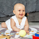 Smiling baby creep on floor of nursery grabbing colorful ball. Baby development. Sensory experience - PhotoDune Item for Sale