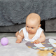 Baby creep on floor of nursery grabbing colorful ball. Baby development. Sensory experience - PhotoDune Item for Sale