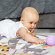 Baby creep on floor of nursery grabbing colorful ball. Baby development. Sensory experience - PhotoDune Item for Sale