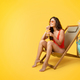 Satisfied millennial mixed race lady in swimsuit sits in deck chair with glass of tropical cocktail - PhotoDune Item for Sale