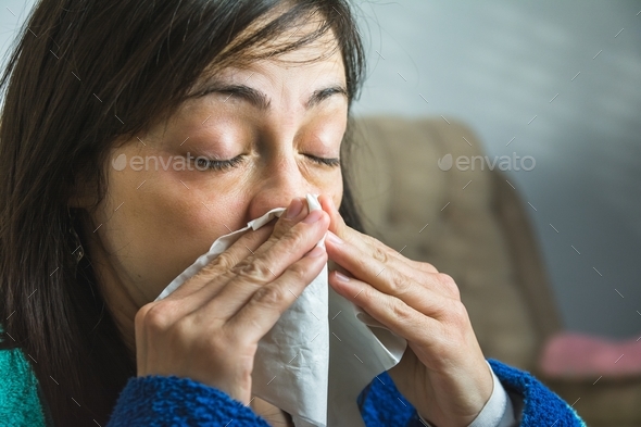 Woman about to sneeze holding a handkerchief in front of her face
