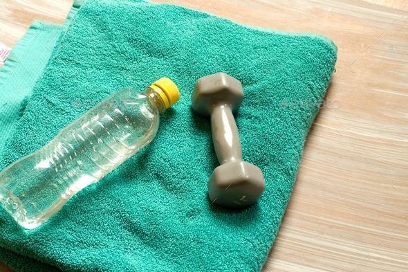 Yoga mat with bottle of water, dumbbells and towel on white background  Stock Photo